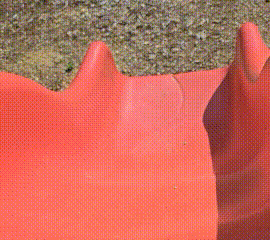 a yellow stuffed animal is sitting on a red surface