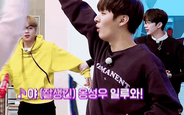 a man in a yellow hoodie is standing next to a man in a purple sweatshirt with the word permanent on it .