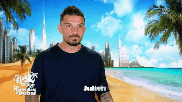 a man with the name julien on his shirt stands in front of a beach scene
