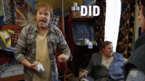 a man standing in front of an arcade machine that says game over on it
