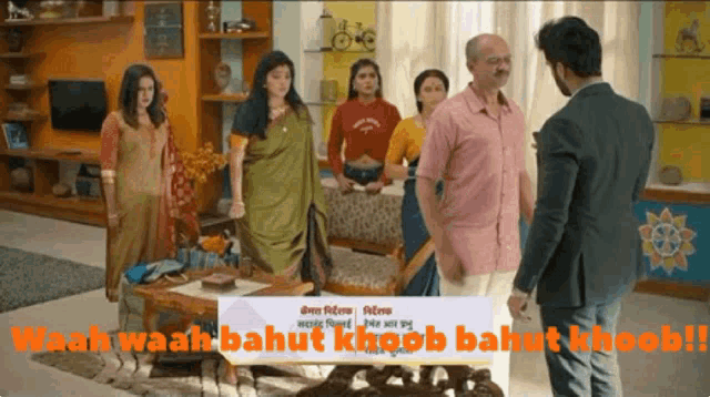 a group of people standing in a living room with a sign that says waah waah bahut khoob bahut khoob !!