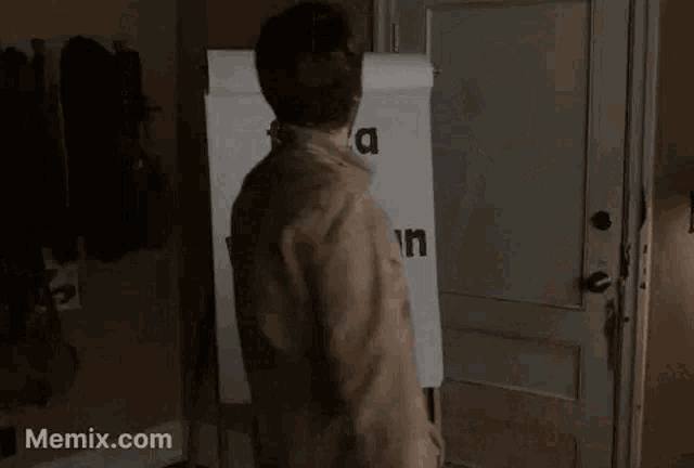 a man is standing in front of a white board that says fizza = voitajan valinta