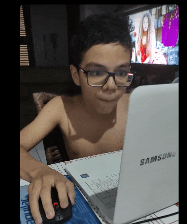 a boy wearing glasses looks at a samsung laptop