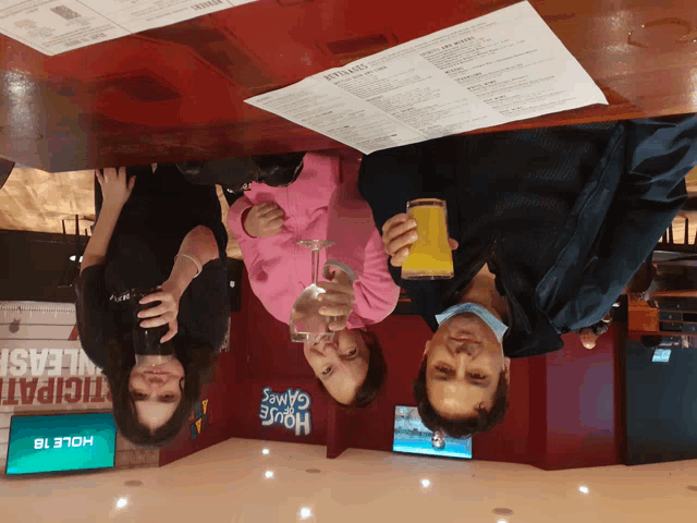 a group of people sitting at a table in front of a sign that says house games