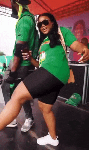 a woman in a green shirt dancing with a man