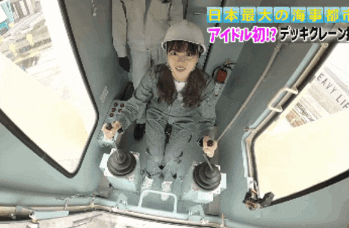 a woman in a hard hat is sitting in an elevator with a sign that says easy lift