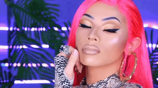 a woman with bright pink hair and a ring on her finger