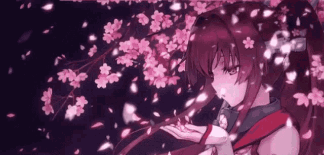 a girl is standing under a cherry blossom tree .