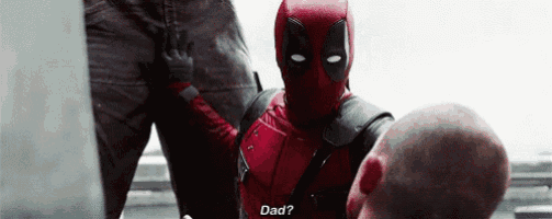 a man in a deadpool costume is talking to another man in a suit .