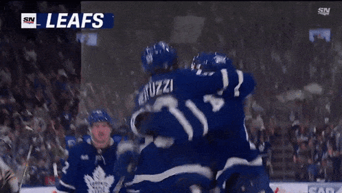 a group of hockey players are celebrating a goal