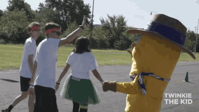 a group of people holding hands with a twinkle the kid mascot behind them
