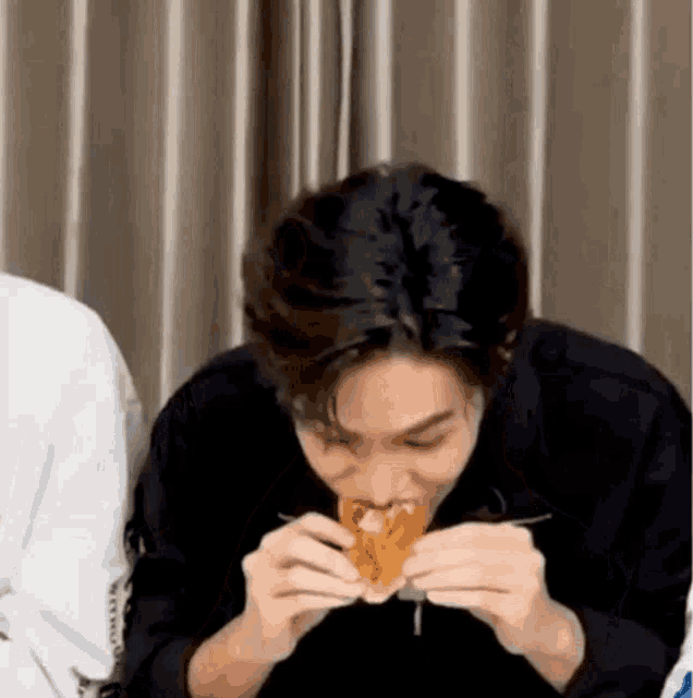a man is eating a sandwich with a fork .