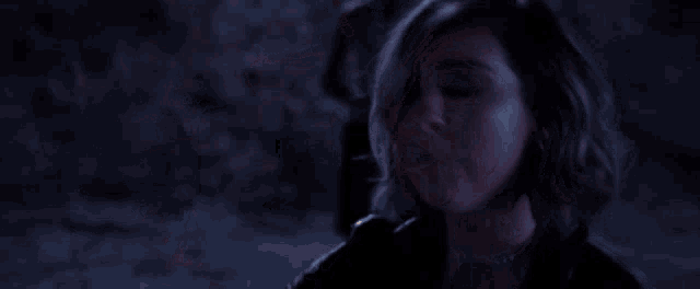 a woman in a dark room with a candle in her hand .