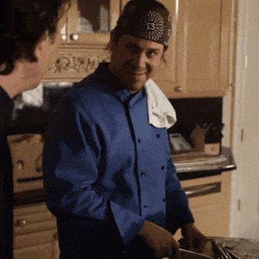 a man wearing a bandana with the letter e on it is smiling