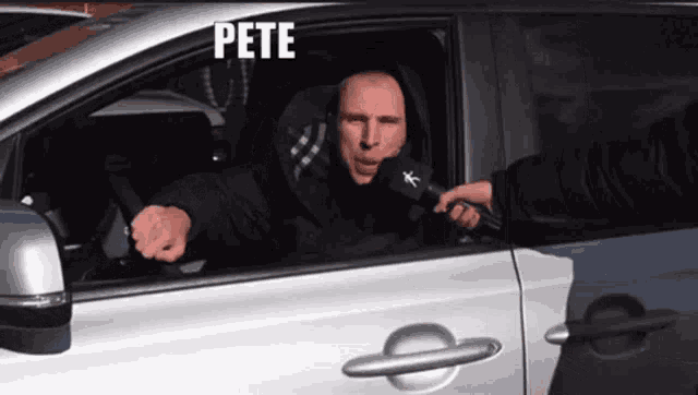 a man is sitting in a car talking into a microphone and the word pete is on the bottom right