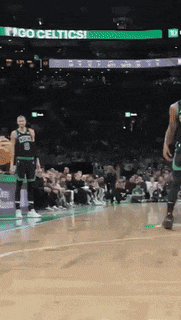 a basketball game is being played in front of a crowd with a sign that says go celtics