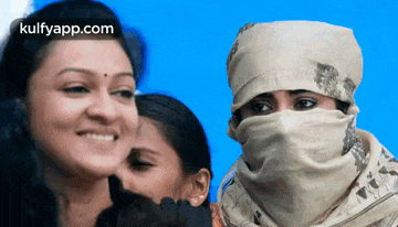 a woman with a scarf around her face is smiling next to two other women ..