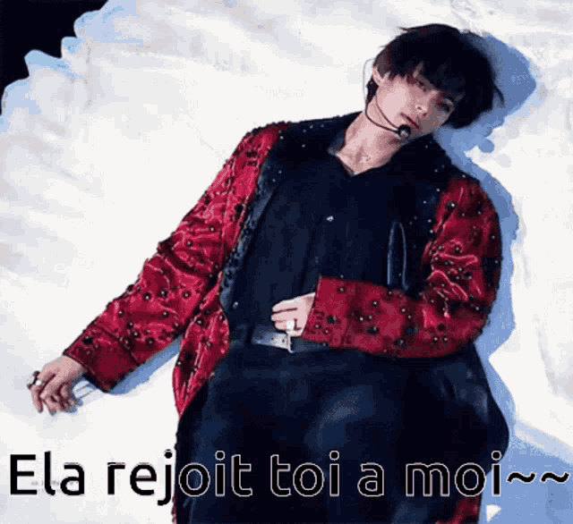 a man in a red jacket is laying on a white surface with the words ela rejoit toi a moi written below him