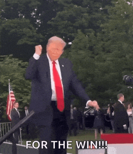 a man in a suit and tie is dancing in front of a crowd and says for the win .