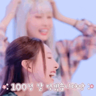 two girls are laughing and one has her hand on her head while the other has her hand on her face .