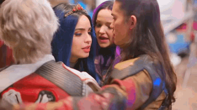 a group of girls are standing next to each other on a street . one of the girls has blue hair .