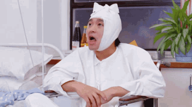 a person with a bandage on their head sitting in a hospital bed