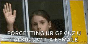 a girl is looking out of a window and waving her hand .