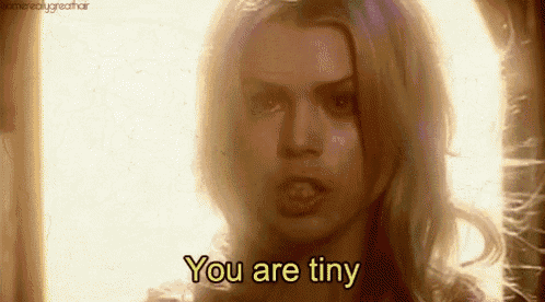 a close up of a woman 's face with the words `` you are tiny '' written on it .