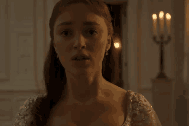 a woman in a white dress is standing in a room with candles