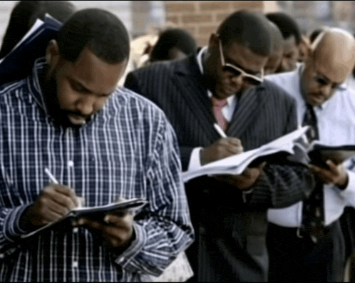 a man in a plaid shirt is writing on a clipboard