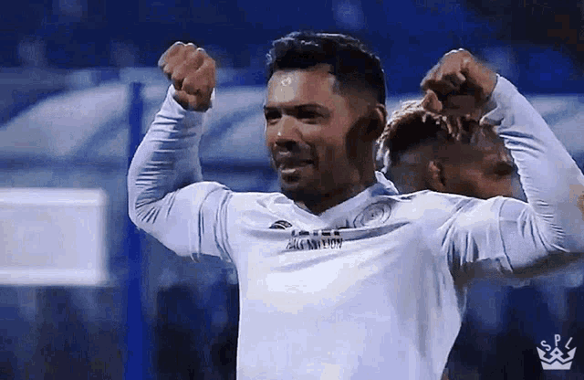 a soccer player in a white shirt with a crown on his chest