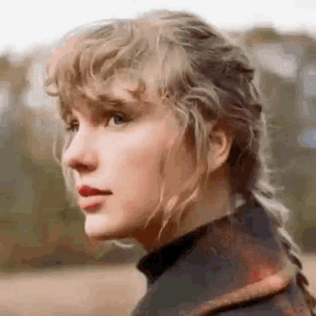 taylor swift is wearing a plaid jacket and a braided ponytail while standing in a field .
