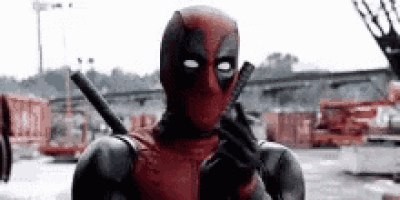 a man in a deadpool costume is holding a gun in his hand .