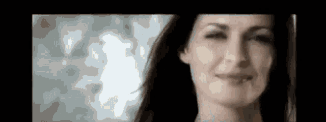 a close up of a woman 's face with a blurred background .