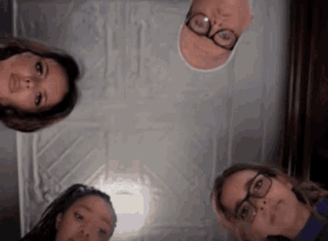 a group of people are looking up at the camera while standing in a circle .