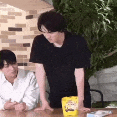 a man in a black shirt is standing next to a man in a white shirt .
