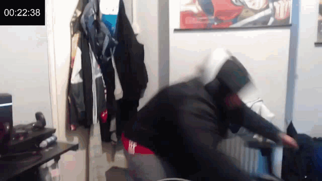 a man is standing in a room with a sign that says 00:22:38 on it