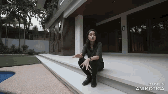 a woman is sitting on the steps of a house made in animotica