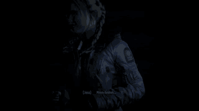 a woman in a jacket is talking to another woman in the dark