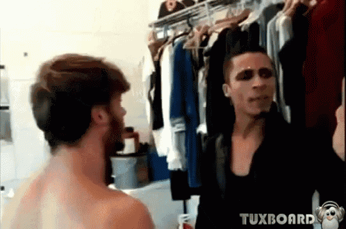 two shirtless men are standing in front of a clothes rack with tuxboard written on the bottom of the screen