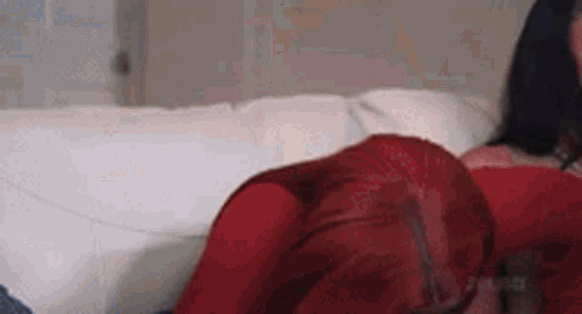 a woman with red hair is laying on a white couch .