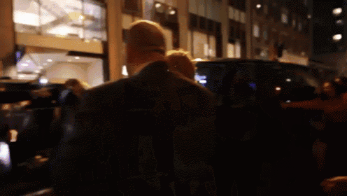 a blurry picture of a man walking down a street at night