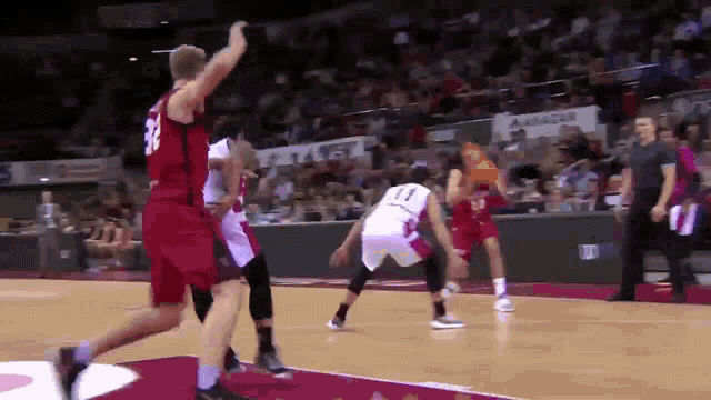 a basketball game is being played in front of a crowd with a banner that says ' allianz ' on it