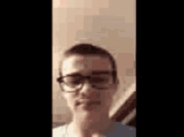 a man wearing glasses is looking at the camera .