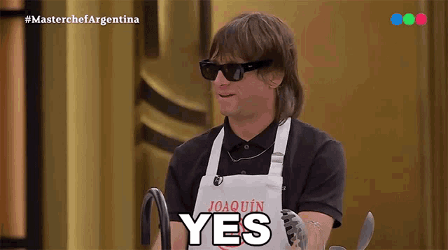 a man wearing sunglasses and an apron that says yes