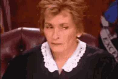 a woman in a judge 's robes is sitting in a courtroom