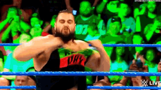 a man in a wrestling ring is wearing a shirt that says ' wwe ' on it .