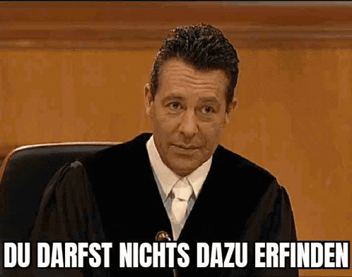 a man in a judge 's robe and tie is sitting in a courtroom and says du darfst nichts
