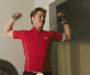 a man wearing a red shirt with the number 427 on it is flexing his muscles
