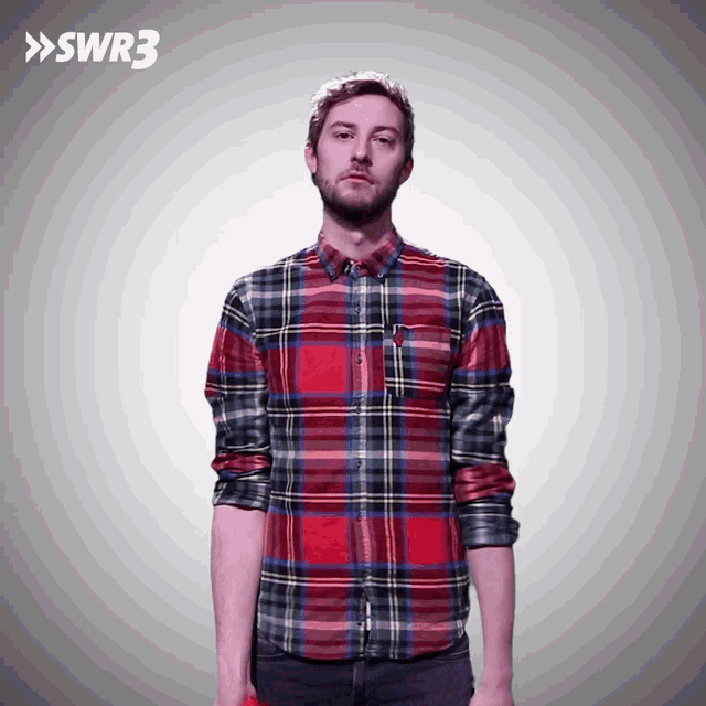 a man wearing a plaid shirt is standing in front of a swr3 logo